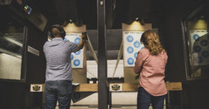 Recreational target shooters at an indoor range.