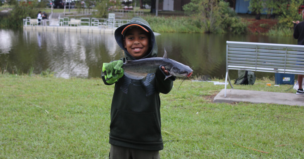 A young angler holding a catfish in Louisiana