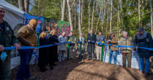 Group of people gathered to cut ribbon