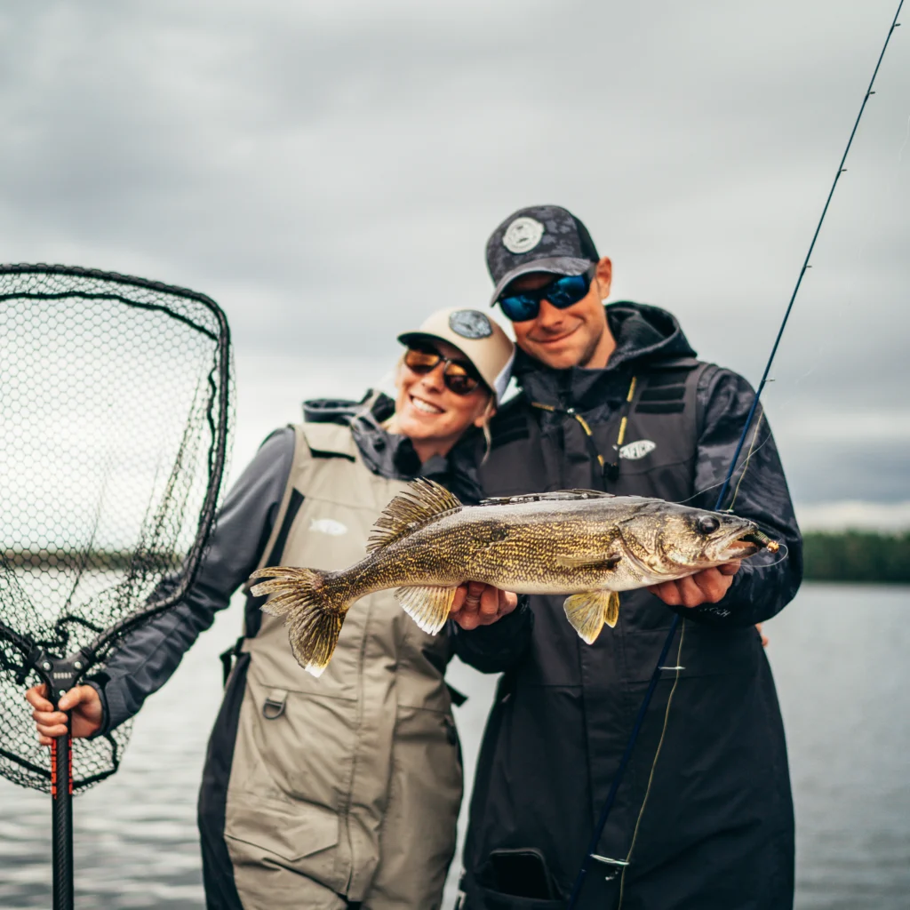 A man and woman holding the fish they caught