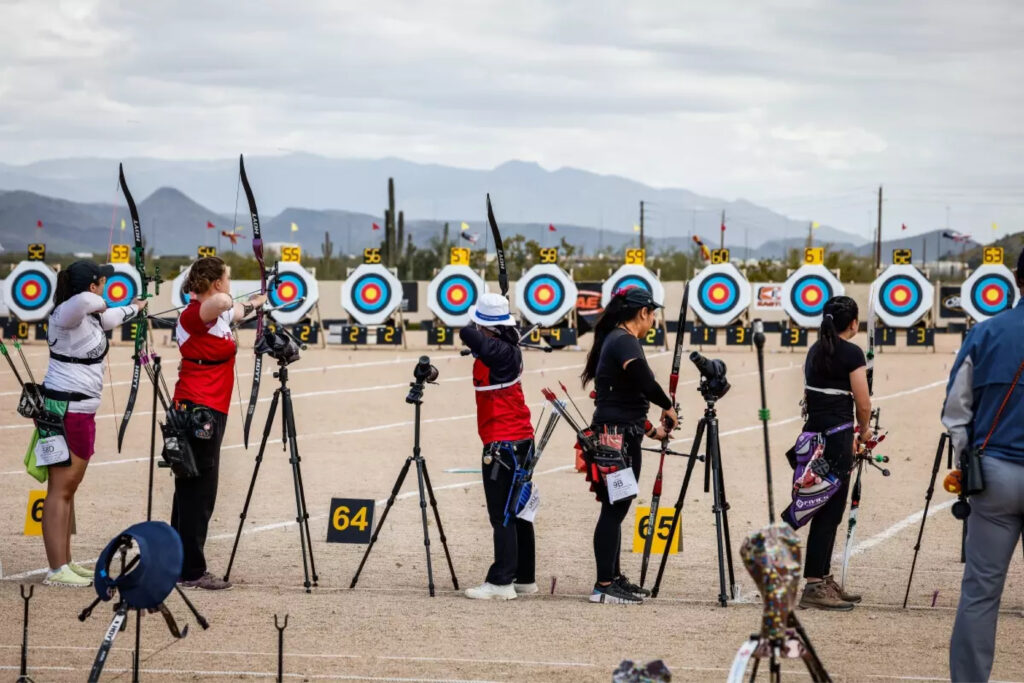 Recurve bow archers line up and aim at targets during the 2024 Arizona Cup.