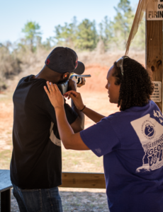 Mentor Showing Student Correct Stock Placement At Target Shooting Range 