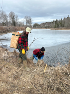 Jake and Riley Debow setting trap along waterway.