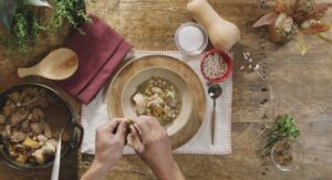 Kitchen table with bowl of stew and ingredients 