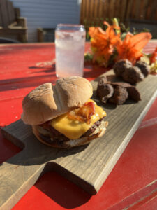 A burger made with wild-harvested meat is laid out on a picnic table.